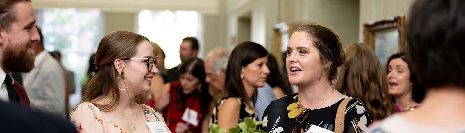 Young Longwood alumni talk together at an alumni gathering.