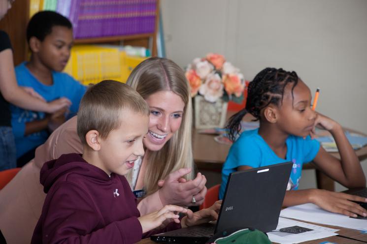 Teaching Student working with two children at computers