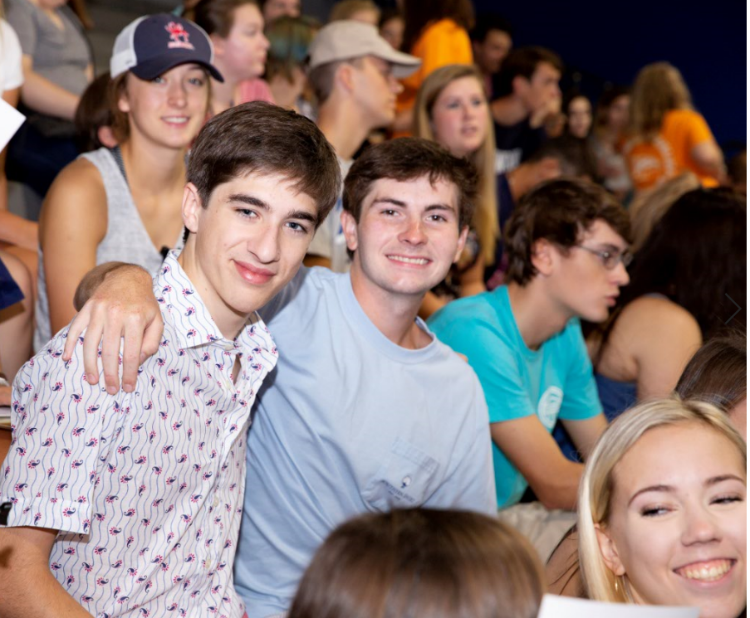 two male students in a half hug at the honor and integrity ceremony