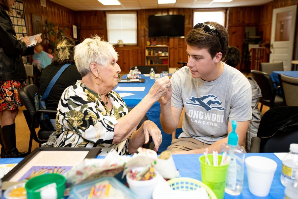 Longwood student participates in a hands-on class activity with an older adult from the Farmville community