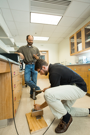 Buckley drives a nail through a piece of self-healing thermo-plastic in the laboratory.