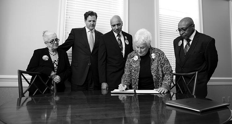 Margaret Leake (left), Longwood President W. Taylor Reveley IV, Joe Leake Jr. and Joe Leake Sr. look on as Ellie Miller makes the Todd Davis Miller Memorial Scholarship official.