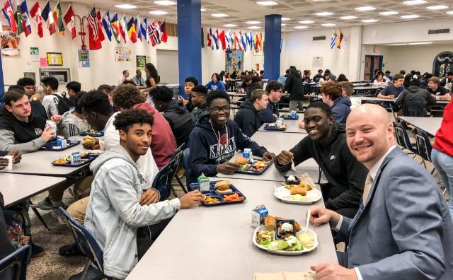 Adam Russo '07 with students in the school dining hall