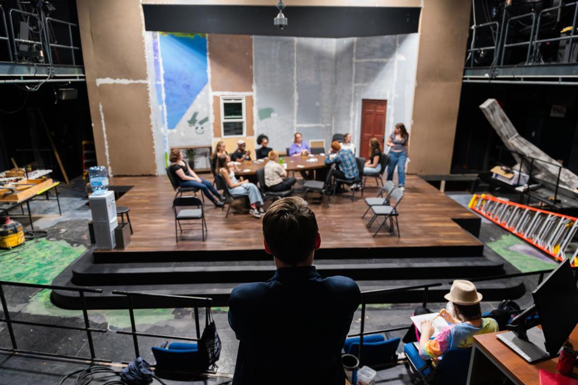 The cast rehearse for 12 Angry Jurors under the director's guidance.