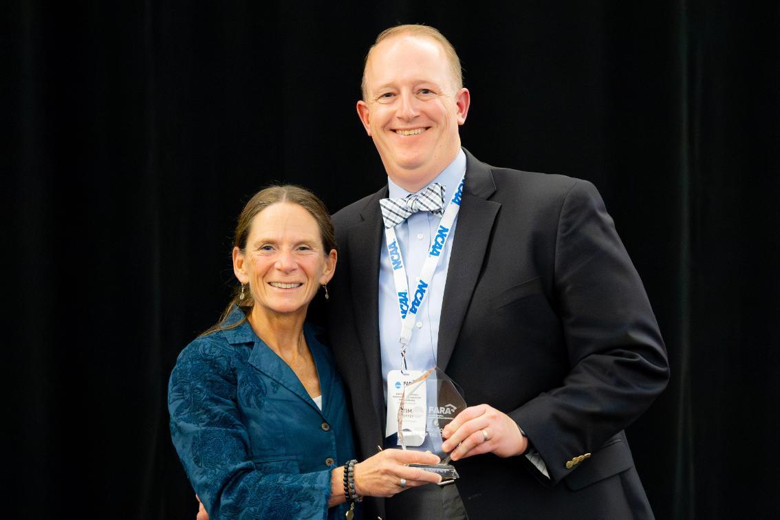 Dr. Tim Coffey is presented his Faculty Athletics Representative of the Year award by Dr. Pam Bruzina, President of FARA