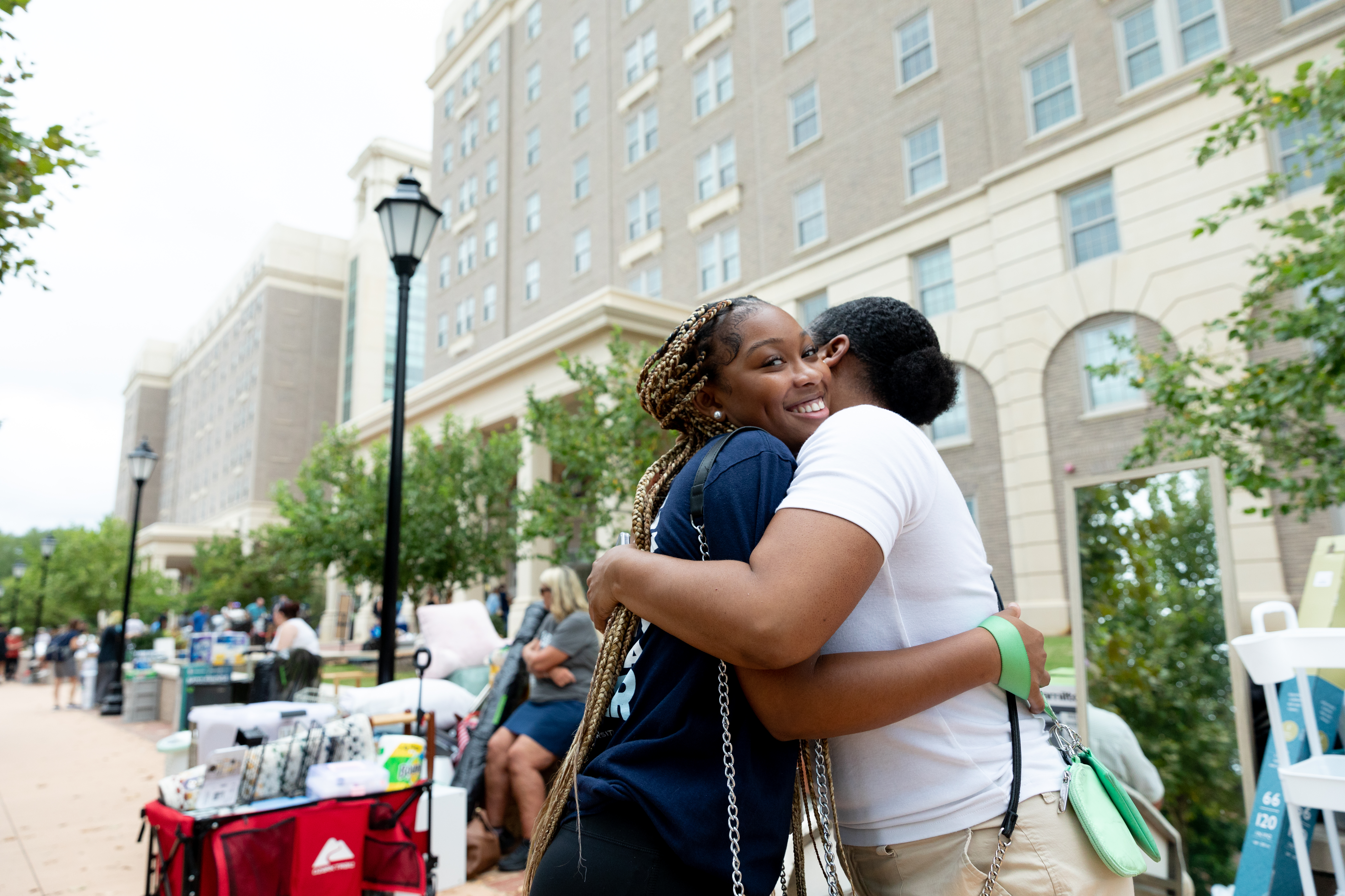 Family member hugs their student in from of Moss Hall