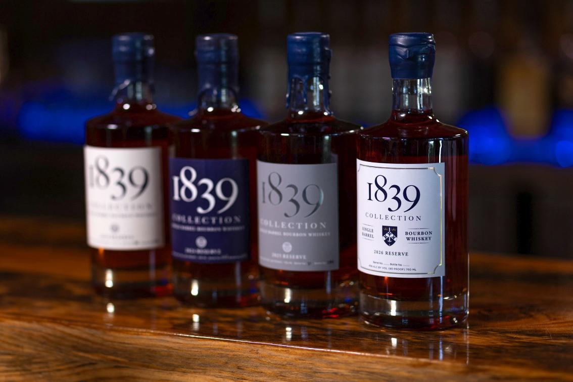 Four bottles of Longwood’s 1839 Collection bourbon whiskey are displayed on a wooden bar, including the 2026 Reserve bottle in front.