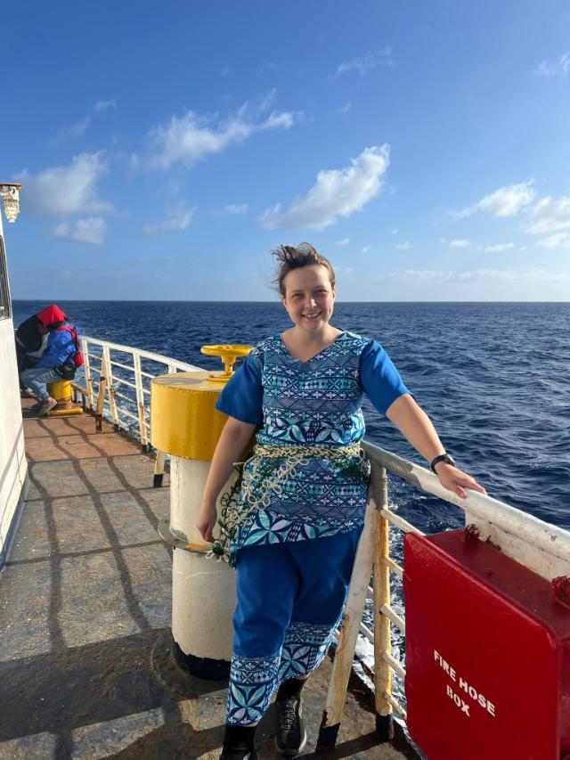 Taylor Bauer '20, M.S. '21 wears a traditional, modest Tongan outfit, consisting of a skirt and shirt, with a hand-woven kiekie around her waist.